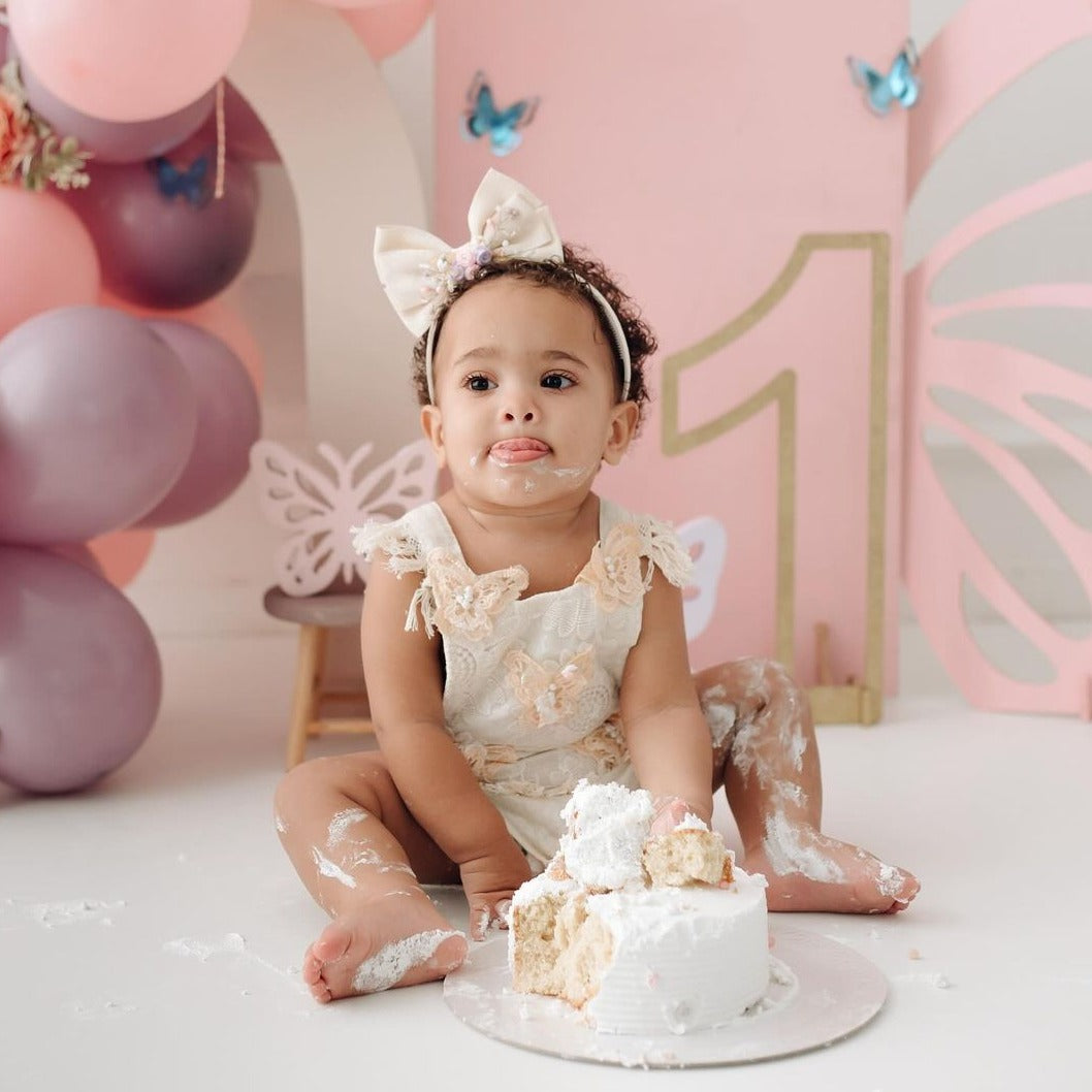 Children's beige bodysuit with butterfly