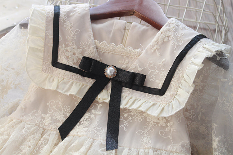 Delicate children's dress with lace and black bow